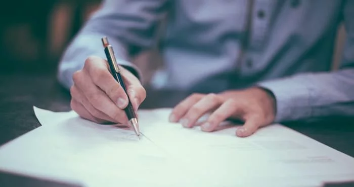A person carefully comparing Will Writing Services Dorking options on a clipboard or laptop